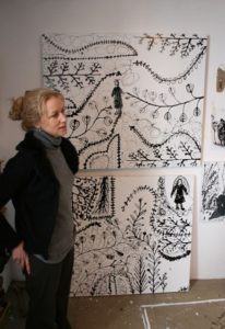 photo of the artist in her studio with monochrome paintings